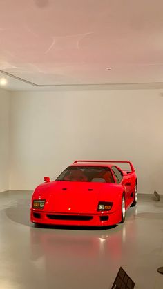 a red sports car parked in a white room