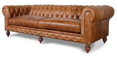 a brown leather couch sitting on top of a wooden table