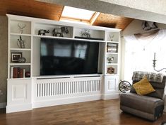 a living room with an entertainment center and bookshelves on the wall in front of it