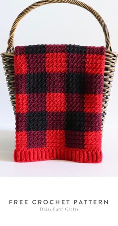 a red and black plaid purse sitting on top of a white table next to a wicker basket