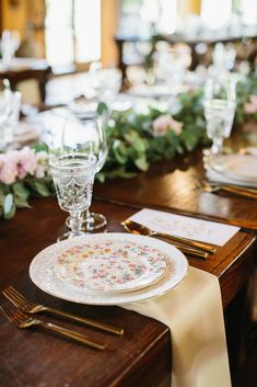 the table is set with plates, silverware and napkins for an elegant dinner