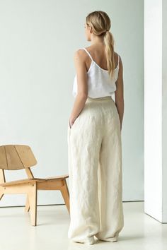 "High waisted linen palazzo pants with pockets. These linen trousers share many elements of suit pants not present in traditional linen pieces: a belt ribbon, zip closure, pleats, slant pockets, etc. Pick these wide-leg pants and you will shine in classy elegance beloved by Italians. Complete your outfit with a matching linen jacket and a classic or minimalistic blouse. ABOUT US LINEN ID was born from desire to embrace things that actually matter. We aim to create sustainable garments that offer White Linen Wide-leg Pants, White Linen Wide-leg Bottoms, White Linen Wide Leg Bottoms, Solid Linen Wide-leg Pants, Solid Linen Trousers, Summer Flax Wide Leg Work Pants, Flax Wide Leg Pants For Work In Summer, Flax Wide Leg Relaxed Fit Pants, Straight Linen Culottes With Pockets