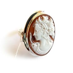 "Shell cameo ring featuring Diana goddess profile hand carved from brown Sardonyx seashell and set in 925 sterling silver. Cameo size: 2-2,5 cm Ring size: on request Contact me for any other request | Customized works also available. Our cameo tecnique respects the ancient cameo tradition consisting in a shell, gemstone, coral, mother of pearl carved with a design in low relief in which the raised design and the background consist of layers of contrasting colours. Every item is really unique bec Formal White Cameo Rings, Diana Goddess, Cameo Bracelet, Contrasting Colours, Cameo Earrings, Cameo Jewelry, Cameo Ring, Cameo Necklace, Cameo Brooch