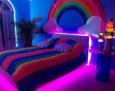 a rainbow themed bedroom is lit up with neon lights