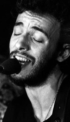 a man singing into a microphone with his eyes closed