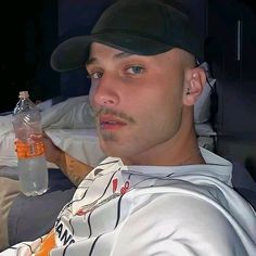 a man wearing a baseball cap and holding a water bottle