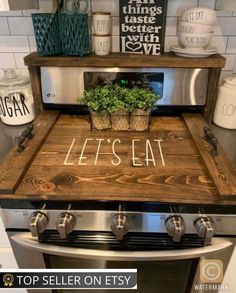 an oven with the words let's eat written on it and a potted plant