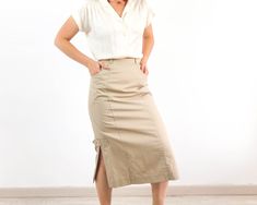 Amazing vintage high waist midi pencil skirt in tan beige. This vintage minimalist midi skirt has waist with belt loops and back button and zip closure, side splits and pockets. The 80's wiggle pencil skirt is cotton and polyester fabric with inner lining in excellent vintage conditions by Mode Weiss. The size skirt is Small, the waist contour fit is 25,1 inches (64 cm). ** MEASURES FLAT ** Waist 12,5 in // 32 cm Hip 19,3 in // 49 cm Length 30,7 in // 78 cm Reference: Model size S (4 US - height Cotton Fitted Midi Pencil Skirt, Cotton Midi Pencil Skirt, Classic Summer Pencil Skirt For Office, Beige Cotton Pencil Skirt, Spring Office Pencil Skirt With Pockets, Classic Summer Workwear Pencil Skirt, Summer Office Midi Bottoms, Summer Office Pencil Midi Skirt, Summer Office Midi Pencil Skirt