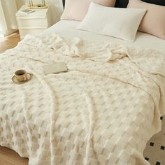 a bed with white blankets and pillows on it