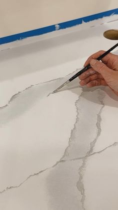 a person is using a brush to paint the floor