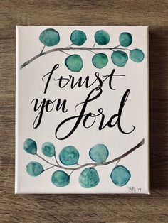 a painting with the words trust you lord on it, and some green leaves around it