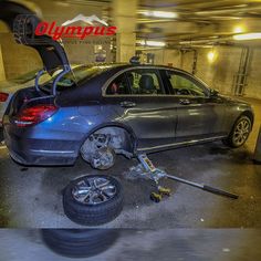 a car is parked in a parking garage with it's door open and the front tire on the ground