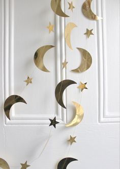 some gold stars and crescents are hanging from the door with white walls in the background