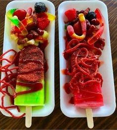 two trays filled with different types of fruit on skewers next to each other