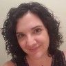 a woman with curly hair is smiling for the camera while wearing a black tank top