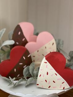 two heart shaped boxes with sprinkles on them sitting next to each other