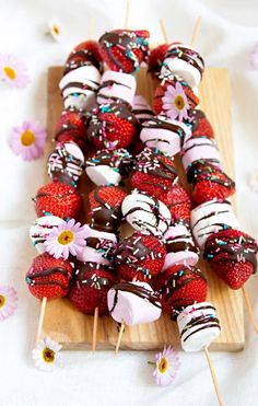 chocolate covered strawberries on skewers with sprinkles and daisies