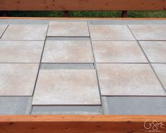 a wooden bench sitting next to a cement floor