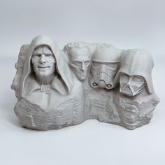 a sculpture of two people with helmets on their heads and one is looking at the camera