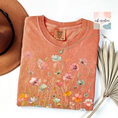 Boho Wildflower Comfort Colors Shirt, Wildflowers Cottagecore Shirt, Boho Wildflower Tshirt, Floral Botanical Shirt Women, Flower Garden Lover Gift  ❤ Comfort Colors® Brand Shirts & Unisex Adult Sizing The softly washed, garment-dyed fabric adds extra comfort to your wardrobe, and its relaxed fit makes it a great everyday choice. The shirt's double-needle stitching enhances its durability, and the absence of side seams helps it maintain its tubular shape. ❤ Please note that the rolled sleeves in Wildflower Pocket Shirt Embroidered, Orange Floral Print Shirt For Spring, Orange Short Sleeve Tops With Floral Embroidery, Orange Floral Embroidery Short Sleeve Tops, Orange Floral Embroidered Cotton Top, Orange Floral Embroidered Short Sleeve Tops, Orange Cotton Top With Floral Embroidery, Orange Floral Print Cotton Shirt, Orange Cotton Floral Print Shirt