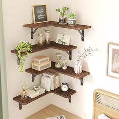 three wooden shelves with plants and books on them in a bedroom area next to a bed