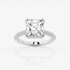 an emerald cut diamond ring with pave set shoulders