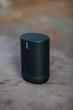 a black speaker sitting on top of a wooden table