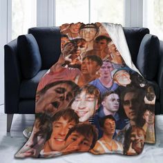 a throw blanket with the faces of many people on it in front of a couch