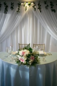 the table is set with white and pink flowers