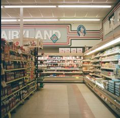 an aisle in a grocery store filled with lots of food and drink bottles on the shelves