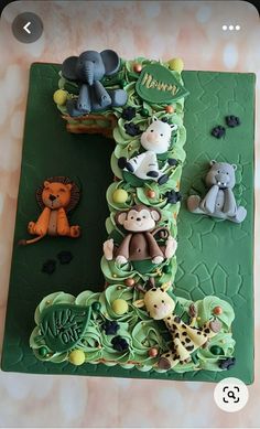 there is a cake with animals on it that looks like the letter i made out of fondant