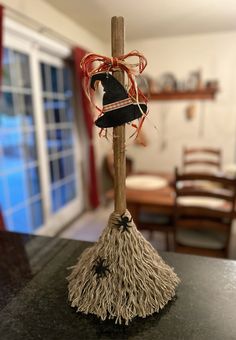 a broom with a witch's hat on it sitting on top of a table