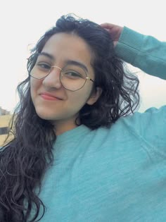 a woman with long hair and glasses posing for the camera