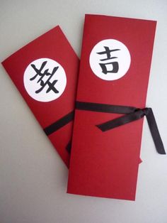 two red envelopes with black ribbon tied around them