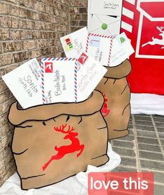 some mail bags are sitting on the ground next to a brick wall with postcards in them