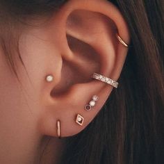 a woman's ear with three different types of piercings