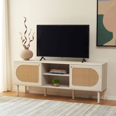 a flat screen tv sitting on top of a white entertainment center