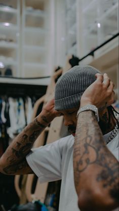 a man with tattoos is holding his head