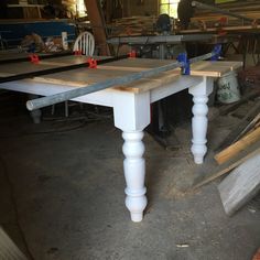 a white table sitting inside of a room filled with wooden planks and plywood