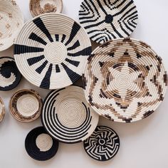 several woven baskets are arranged on a white surface, with black and white designs in the middle