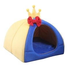 a blue and yellow dog bed with a red bow on it's head in front of a white background