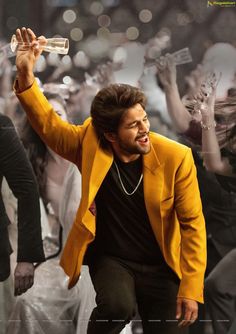 a man in a yellow blazer is holding a bottle and dancing with other people