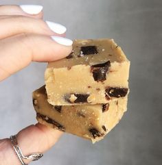 a hand holding two pieces of chocolate chip fudge