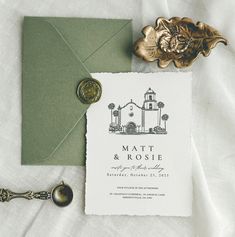 the wedding stationery is laid out next to an envelope with a wax stamp on it