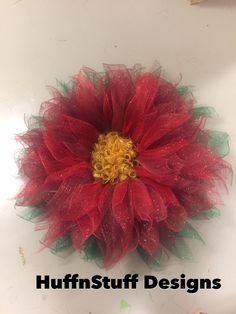 a large red flower with green leaves on it's head and the words, tufts designs