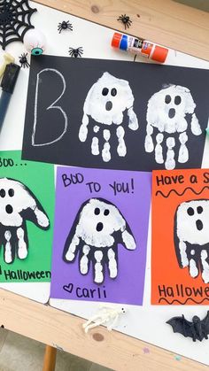 handprinted halloween cards on a table with crayons and markers for writing