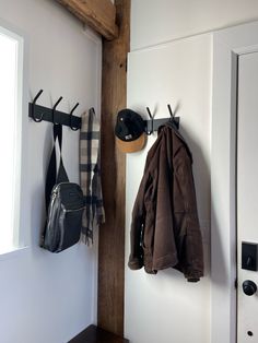 a coat rack with two coats hanging from it's hooks next to a door