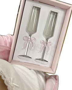 two champagne flutes in a pink box with ribbon and bow on the side, sitting next to each other