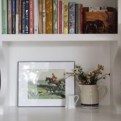 the bookshelf is full of books and vase with flowers