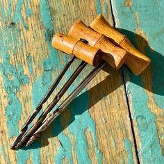 three wooden dowks are sitting on a blue and yellow painted wood surface with peeling paint